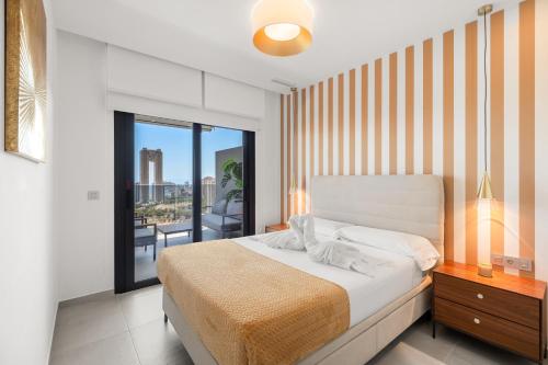 a bedroom with a bed and a balcony at Skyline Infinity Apartment Eagle Tower Benidorm in Benidorm