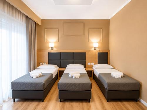 a room with three beds in a room at EURHOTEL in Florence