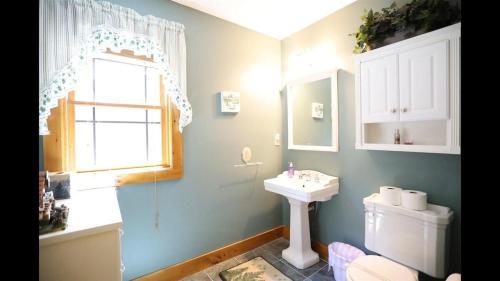 a bathroom with a sink and a toilet and a window at Welch View 68 Thornton Deluxe Private 4 Bedroom Home in Thornton
