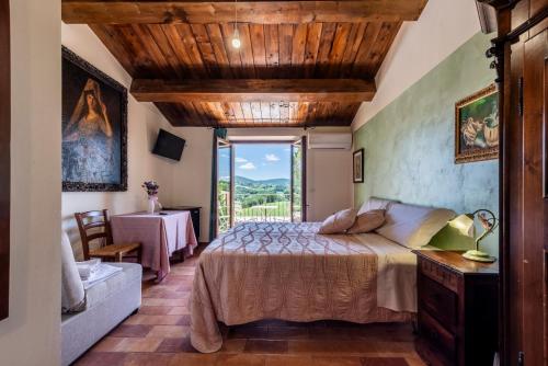 a bedroom with a bed and a large window at La Corte Sul Lago in Cingoli