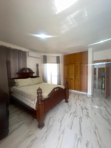 a bedroom with a bed with a marble floor at Las Tres Casitas in San Felipe de Puerto Plata