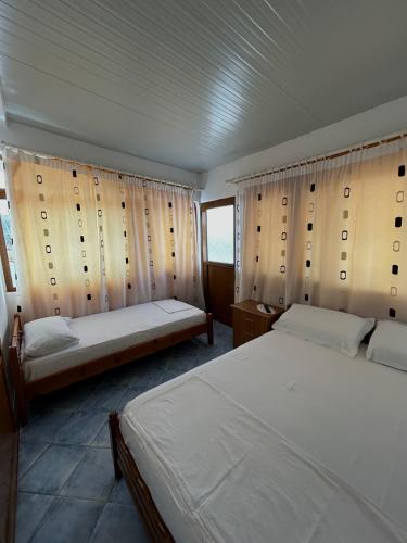 a bedroom with two beds and a window at Vila Vladmir Sela in Ksamil