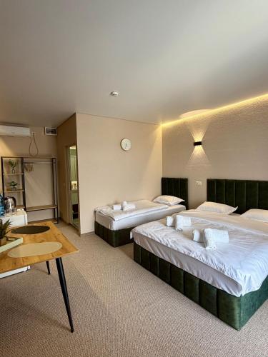 a hotel room with two beds and a table at Villa HOLM in Solotvyno