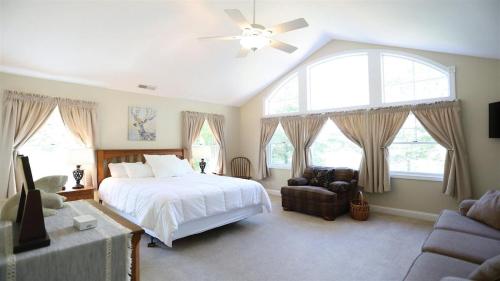 a bedroom with a bed and a couch and windows at Rising Ridge 28 Owls Nest Deluxe Pet friendly Home at Owl`s Nest in Campton