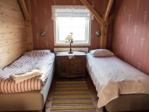 two twin beds in a room with a window at Allsta Gård Kretsloppshuset B&B in Bjärtrå