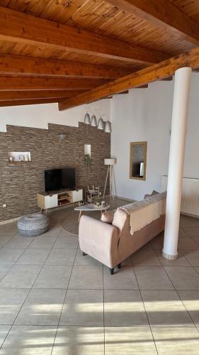 a living room with a couch and a television at Théa Loft Premium Sunset Sea View Escape in Vathý