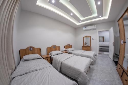three beds in a room with a skylight at The view apartment 2 in Al Baha