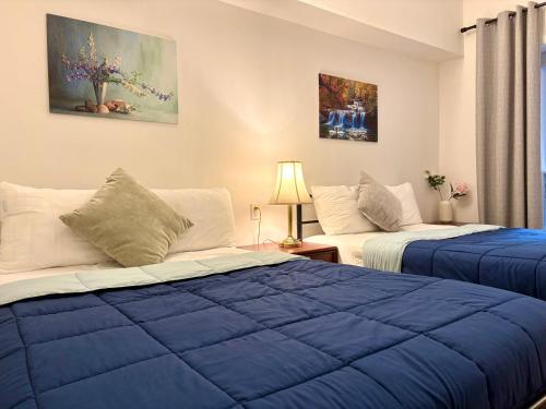 two beds in a room with blue sheets at Hotel La Residence du Voyageur in Montreal
