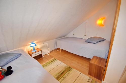 a room with two beds and a lamp on a table at "Tuna Sol" in Vimmerby