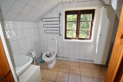 a white bathroom with a toilet and a window at "Tuna Sol" in Vimmerby