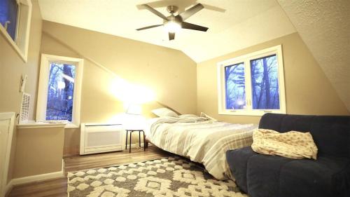a bedroom with a bed and a ceiling fan and a couch at Green Circle 29 Estates Pet Friendly Private Home in Waterville Estates in Campton