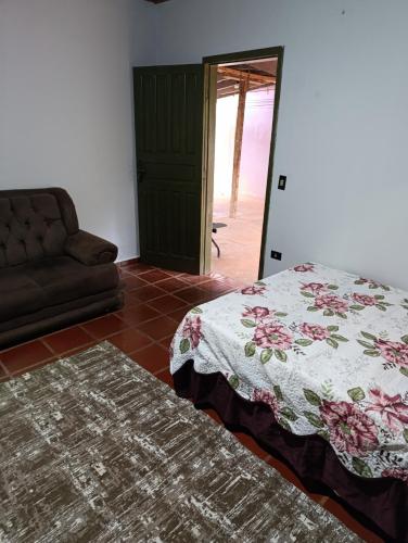 a living room with a bed and a couch at cantinho da paz in Dourados