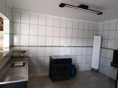 a small kitchen with a stove and a sink at cantinho da paz in Dourados