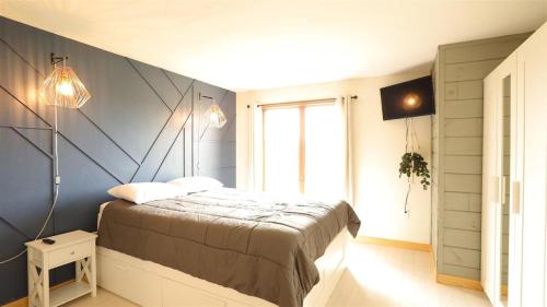 a bedroom with a bed with a blue wall at Valley View 4 Campton White Mountain Condo With Views in Campton