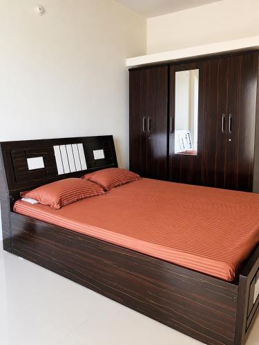 a bedroom with a wooden bed with a wooden headboard at Sai Mahima Stays in Shirdi