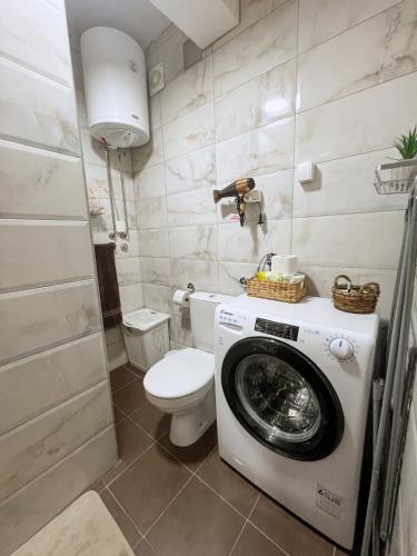 a bathroom with a washing machine and a toilet at Green Paradise in Vrnjačka Banja