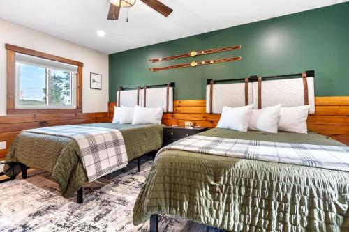 two beds in a room with green walls at The Inn at the Rostay in Bethel