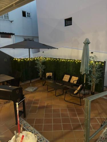 a patio with an umbrella and chairs and a table at Panxón Primera Linea Mar in Nigrán
