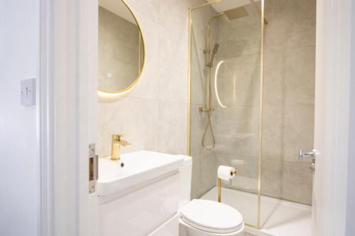 a bathroom with a toilet and a sink and a mirror at Best in Class - London, Harrow in Harrow