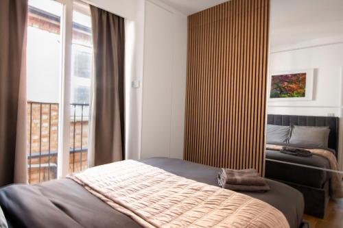 a bedroom with a bed and a large window at Best in Class - London, Harrow in Harrow