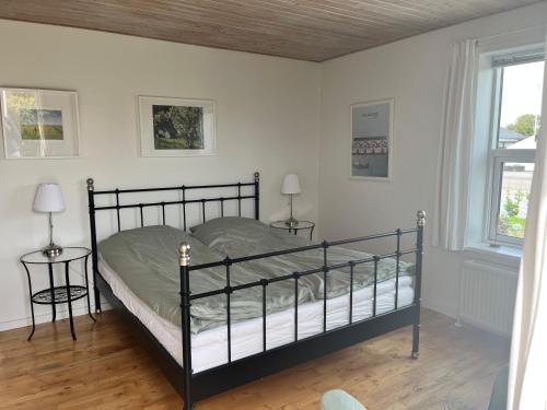 a bed in a room with two tables and two lamps at Eddies Bed & Breakfast in Skagen