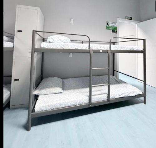 a bunk bed room with three bunk beds in it at Hostel LAS ROSAS in Madrid
