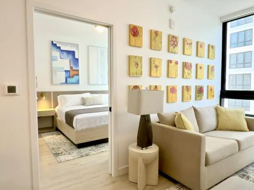 a living room with a couch and a bed and a mirror at Chic Luxury 1BR Oasis in Miami