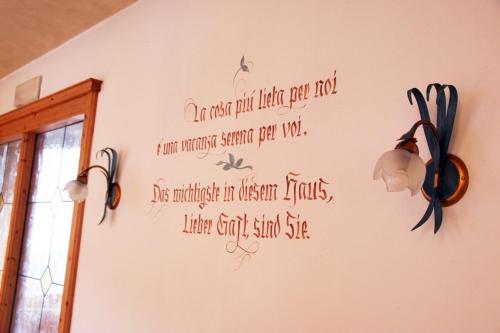 a wall with a writing on it with lights on it at Hotel Garni Ongaro in Selva di Cadore