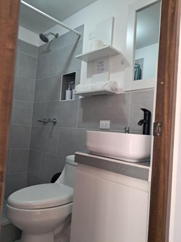 a bathroom with a white toilet and a sink at 7min del Parque Central-2min Rotonda Marimba, en la naturaleza Tipo LOFT5 in Quetzaltenango