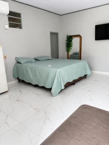 a bedroom with a bed and a mirror at Studio Brasiléia in Brasiléia