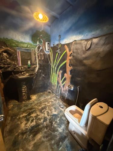 a bathroom with a painting on the wall and a toilet at Okan Rock Residence in Ella