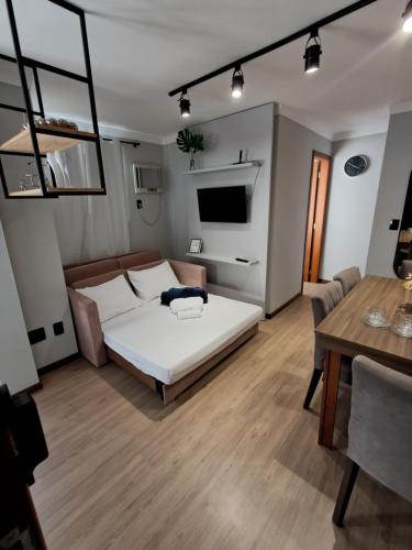 a bedroom with a bed and a dining table at Apartamento completo e perfeito, Ao lado da Weg in Jaraguá do Sul