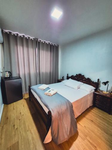 a bedroom with a large bed with white sheets at Hotel El-Shaday in Vila Nova do Sul