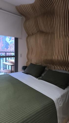 a bedroom with a large bed with a wooden headboard at U House in São Paulo