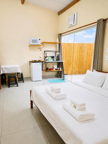 a bedroom with a large bed with two white towels on it at Chalés & Suítes Praia Barequeçaba I Cozinha Compacta in São Sebastião