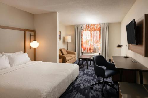 a hotel room with a bed and a desk at Fairfield Inn & Suites Lansing West in Delta Center Township