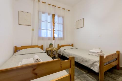 two twin beds in a room with white walls at Agia Paraskevi Villa Olive in Makri