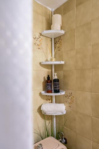 a bathroom with a toilet and towels on shelves at Agia Paraskevi Villa Olive in Makri