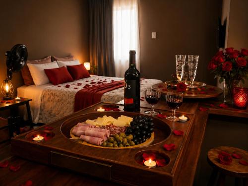 a table with a plate of food and a bottle of wine at Aconchego Valença & Spa in Nova Friburgo