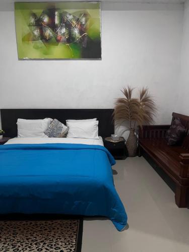 a bedroom with a blue bed and a couch at D,lacoco in Kubupenlokan