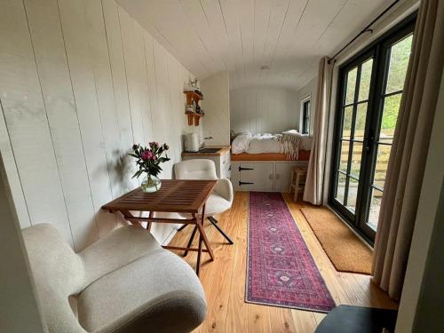 a room with a table and chairs and a bedroom at Shepherds Hut in Penzance in Newlyn