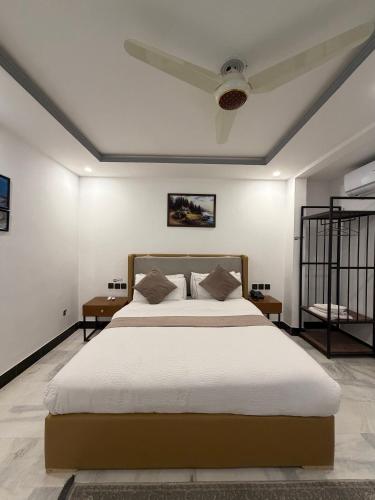 a bedroom with a large bed and two tables at Prestige by Alnoor in Skardu