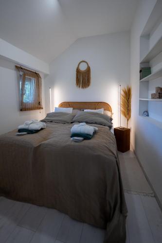 a bedroom with a large bed with two towels on it at Világos Kert Oliva House Steam in Balatonvilágos