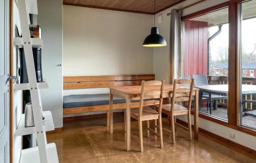 a dining room with a table and chairs and a bed at Degeberga Stugby in Degeberga