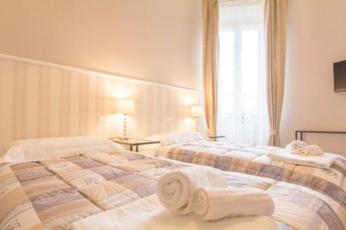 two beds in a hotel room with towels on them at Cittadella 5 in Florence