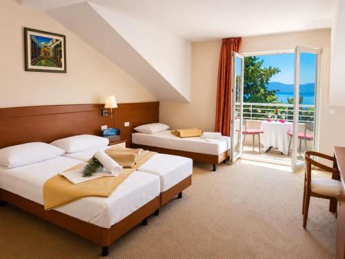 a hotel room with two beds and a balcony at Hotel Neptun Gradac in Gradac