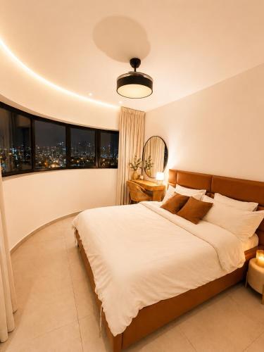 a bedroom with a large bed and large windows at amor premium residence-4BR apartment with balcony in Beer Sheva