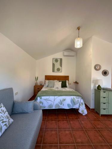 a bedroom with a bed and a couch at Aldeana Rural in El Cubillo