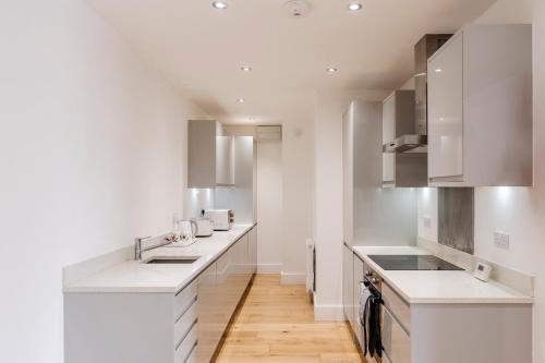 a kitchen with white counters and white cabinets at Sunnymede Court in Billericay