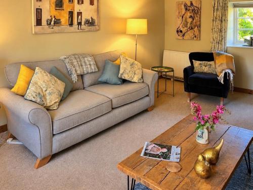 a living room with a couch and a coffee table at Barters Cottage in Chideock